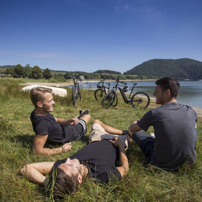 Gruppe junger Leute relaxen am Ufer des Diemelsees