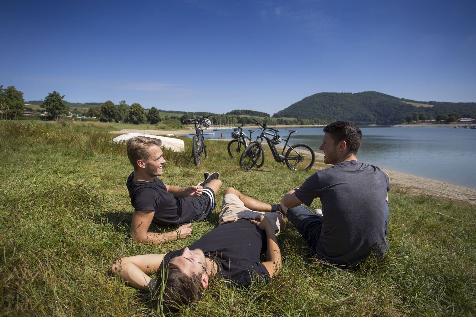 Gruppe junger Leute relaxen am Ufer des Diemelsees