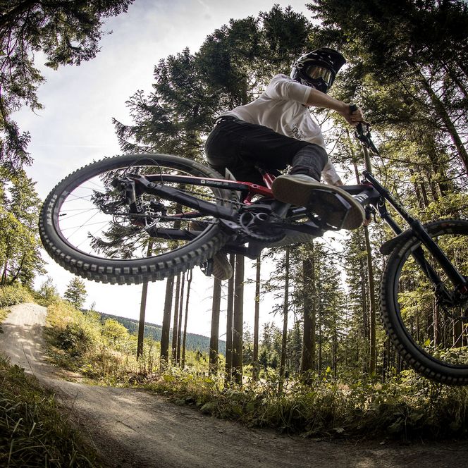 Biker beim Sprung und Akrobatik auf der Freeridestrecke im MTB Zone Bikepark Willingen