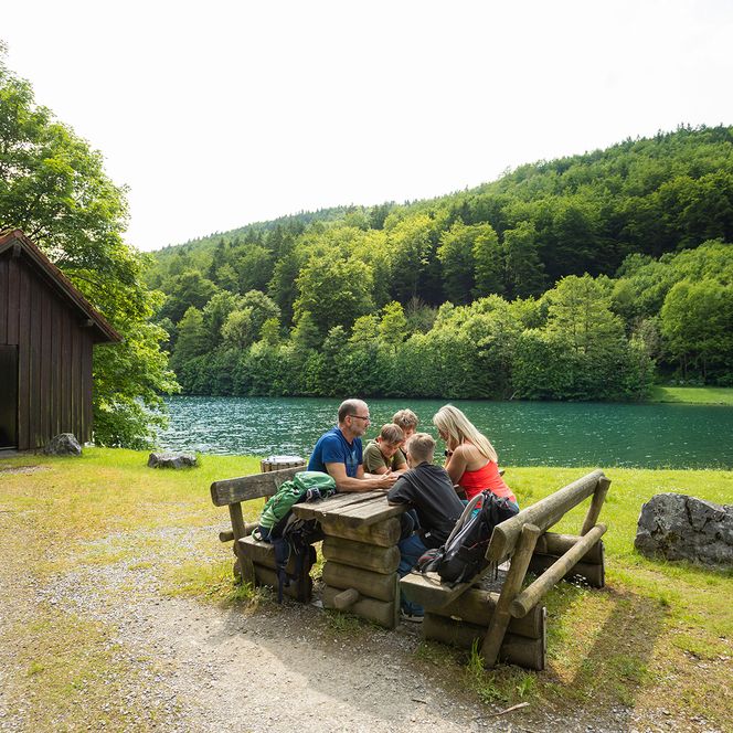Familie sitzt auf einem Rastplatz am See bei Brilon
