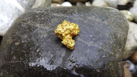 Goldnugget auf dunklem Stein