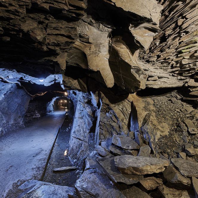 Beleuchteter Gang und gestapelte Schieferwand im Schieferbergwerk Willingen 