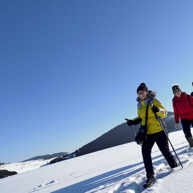 Wandergruppe im Schnee unter strahlend blauem Himmel
