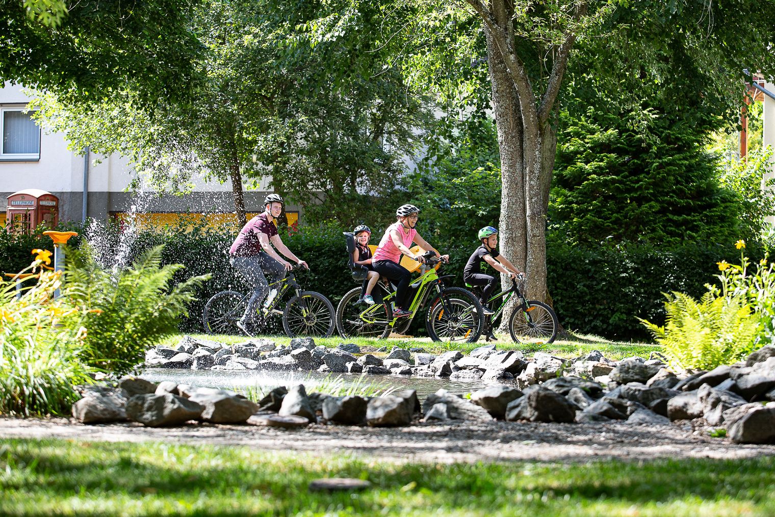 Familie beim Radeln auf dem Diemelradweg an einem Springbrunnen