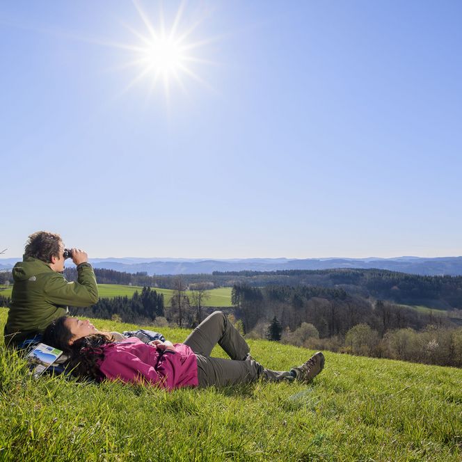 Wanderer bei der Rast auf einer Wiese mit schönem Ausblick